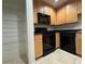 Condo kitchen featuring wooden cabinets, black appliances, and wire shelving at 195 14Th Ne St # 303, Atlanta, GA 30309