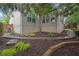 This backyard features a mulched flowerbed with neatly trimmed shrubs and small trees at 202 Roseman Way, Woodstock, GA 30188