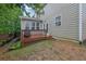 This backyard has a wooden deck, grassy area, and lush surrounding greenery at 202 Roseman Way, Woodstock, GA 30188