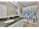 Neutral toned bathroom featuring a vanity with granite countertop and a blue and white patterned shower curtain at 202 Roseman Way, Woodstock, GA 30188