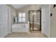Modern bathroom with a jetted tub, a glass enclosed shower, tile floors, and neutral walls at 202 Roseman Way, Woodstock, GA 30188