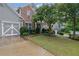 Charming home with a brick facade, lush lawn, and a convenient two-car garage and driveway at 202 Roseman Way, Woodstock, GA 30188