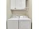 Practical laundry room featuring a side-by-side washer and dryer and overhead storage cabinets at 202 Roseman Way, Woodstock, GA 30188