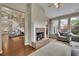 Inviting living room with cozy seating, a warm fireplace, and ample natural light flowing through large windows at 202 Roseman Way, Woodstock, GA 30188
