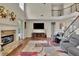 Inviting living room featuring a stone fireplace, hardwood floors, and an open staircase at 202 Roseman Way, Woodstock, GA 30188