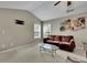 Cozy living room featuring a plush brown sofa, glass coffee table, neutral walls, and a vaulted ceiling at 202 Roseman Way, Woodstock, GA 30188
