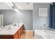This primary bathroom features a soaking tub, double sinks, and modern tile at 2118 Braswell Ln, Loganville, GA 30052