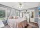 Comfortable bedroom with a ceiling fan, canopy over the bed, and natural light from the windows at 2118 Braswell Ln, Loganville, GA 30052