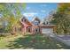 Charming brick home featuring a well-manicured lawn, mature trees, and a two-car garage at 2335 Corbett Ct, Powder Springs, GA 30127