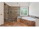 Luxurious main bathroom featuring separate shower and bathtub, and earth-tone tile at 2335 Corbett Ct, Powder Springs, GA 30127
