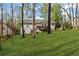 Two-story home featuring a deck and lawn surrounded by lush greenery and trees at 305 Bridgewater Ter, Canton, GA 30115