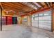 Spacious garage with exposed wood ceiling, shelving, and garage door with multiple windows at 305 Bridgewater Ter, Canton, GA 30115