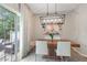 Dining room with modern light fixture, wood table, white chairs, and sliding door to backyard at 2377 Heritage Park Nw Cir # 16, Kennesaw, GA 30144