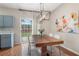 Dining room with modern light fixture, wood table, white chairs, and adjacent to open kitchen at 2377 Heritage Park Nw Cir # 16, Kennesaw, GA 30144
