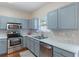 Well-lit kitchen features stainless steel appliances, light-grey cabinets, and speckled tile backsplash at 2377 Heritage Park Nw Cir # 16, Kennesaw, GA 30144