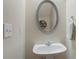 Well-lit powder room with a pedestal sink, decorative mirror, and neutral wall paint at 2377 Heritage Park Nw Cir # 16, Kennesaw, GA 30144