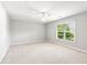 Spacious bedroom with a ceiling fan, large window, and neutral carpet at 3725 Downing Dr, Cumming, GA 30040