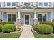 Inviting front entrance with stone-accented columns, manicured shrubs, and a stylish glass-paneled door at 3725 Downing Dr, Cumming, GA 30040