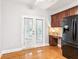 Bright kitchen features french doors, wood cabinets, stainless steel refrigerator, and hardwood floors at 3725 Downing Dr, Cumming, GA 30040