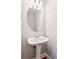 Classic half bath features a pedestal sink, oval mirror, and decorative lighting at 3725 Downing Dr, Cumming, GA 30040