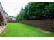 Fenced backyard featuring a large, well-maintained lawn with mature trees at 4645 Wykeshire Ct, Cumming, GA 30041