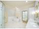 Modern bathroom with a standalone tub, glass shower, double vanity, and abundant natural light at 4645 Wykeshire Ct, Cumming, GA 30041