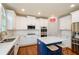 Well-lit kitchen with white cabinets, stainless steel appliances, an island with bar seating and wooden flooring at 4645 Wykeshire Ct, Cumming, GA 30041