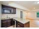 Dark wood kitchenette featuring granite countertops and stainless steel appliances at 4645 Wykeshire Ct, Cumming, GA 30041