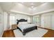 Tranquil bedroom with a large bed, neutral rug, and abundant natural light from shuttered windows at 4645 Wykeshire Ct, Cumming, GA 30041