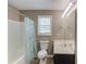 Neutral bathroom with shower-tub combo, single sink vanity, and window at 932 Sugar Meadow Ln, Sugar Hill, GA 30518