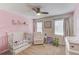 Cozy Bedroom with crib, chair, and whimsical decor at 932 Sugar Meadow Ln, Sugar Hill, GA 30518
