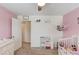 Charming bedroom with a white crib, and whimsical wall decorations at 932 Sugar Meadow Ln, Sugar Hill, GA 30518