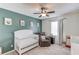 Bright Bedroom room featuring crib, plush chair, and calming green accent wall at 932 Sugar Meadow Ln, Sugar Hill, GA 30518