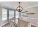 Bright dining room features a modern chandelier, hardwood floors, and wall shelving at 932 Sugar Meadow Ln, Sugar Hill, GA 30518