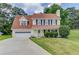 Charming two-story home with attached garage, manicured lawn, and traditional design elements at 932 Sugar Meadow Ln, Sugar Hill, GA 30518