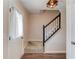 Bright foyer showcasing staircase with wood railing and hardwood floors and decorative front door at 932 Sugar Meadow Ln, Sugar Hill, GA 30518