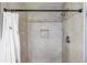 Tiled shower enclosure with decorative accent tiles and a shower head at 932 Sugar Meadow Ln, Sugar Hill, GA 30518