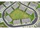 Aerial view of a community featuring modern townhomes surrounding a green space, conveniently located near a highway at 1181 Chastain Dr, Sugar Hill, GA 30518