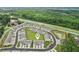 Aerial view of townhomes featuring a manicured central lawn, and proximity to a highway and green space at 1181 Chastain Dr, Sugar Hill, GA 30518
