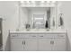White bathroom vanity with double sinks, drawers, and a large mirror at 1181 Chastain Dr, Sugar Hill, GA 30518