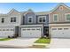 Attractive exterior view of townhomes showcasing garages, colorful sidings, and lovely lawns at 1181 Chastain Dr, Sugar Hill, GA 30518