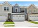 Inviting townhome showing a garage, well-manicured lawn, and beautifully colored siding at 1181 Chastain Dr, Sugar Hill, GA 30518