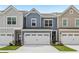 Charming townhome with a two-car garage, colorful siding, and a well-maintained front lawn at 1181 Chastain Dr, Sugar Hill, GA 30518