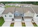 Well-maintained townhomes feature attached garages and inviting curb appeal with neat landscaping and modern design elements at 1181 Chastain Dr, Sugar Hill, GA 30518