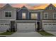 Inviting townhouse exterior with a two-car garage, well-maintained lawn, and pleasing color scheme at 1181 Chastain Dr, Sugar Hill, GA 30518