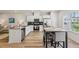 Open kitchen with stainless steel appliances, granite counters, breakfast bar, and adjacent dining area at 1181 Chastain Dr, Sugar Hill, GA 30518