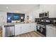 Bright kitchen features stainless steel appliances, granite countertops, white cabinets, and a modern backsplash at 1181 Chastain Dr, Sugar Hill, GA 30518