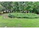 Spacious backyard with lush green grass, flower garden, and mature trees at 1868 Birch Briar Bnd, Lawrenceville, GA 30043