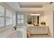 Bright bathroom featuring double sinks, large mirror, garden tub, and plantation shutters at 1868 Birch Briar Bnd, Lawrenceville, GA 30043