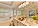 Bathroom with a double sink, large mirror, garden tub, and plantation shutters at 1868 Birch Briar Bnd, Lawrenceville, GA 30043